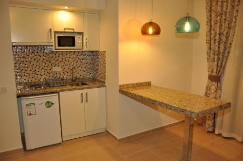 a small kitchen with a counter and a microwave at Almera Park Apart Hotel in Alanya