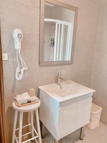 a bathroom with a sink and a mirror and a stool at Alice’s Home in Jinsha