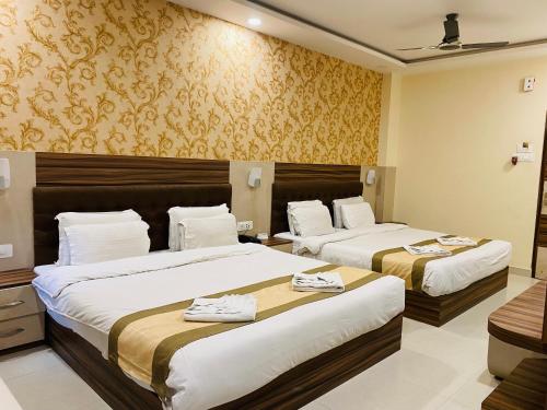a hotel room with two beds with towels on them at Hotel Saayein Residency in Siliguri