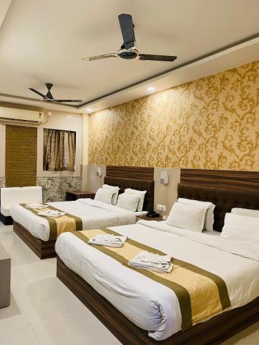a bedroom with three beds in a room at Hotel Saayein Residency in Siliguri