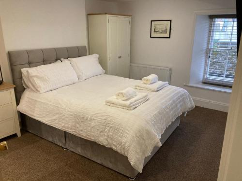 1 dormitorio con 1 cama con toallas en Grade II Listed House in the Lake District - Perfect deployment location for Coast to Coast cyclists & hikers, en Whitehaven