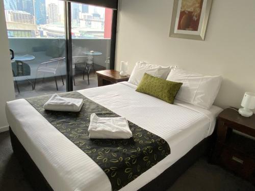 a bedroom with a bed with two towels on it at AKOM AT Docklands in Melbourne