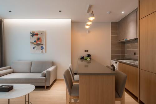 a kitchen and a living room with a couch and a table at Chestertons Sokcho in Sokcho