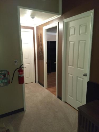 a hallway with a white door and a fire extinguisher at Curt's cozy room rentals in Wendover