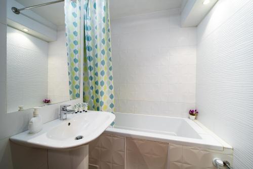 a bathroom with a sink and a bath tub at Lilla Apartments in Odorheiu Secuiesc