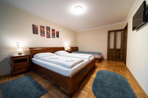 a bedroom with two beds and a flat screen tv at Lilla Apartments in Odorheiu Secuiesc