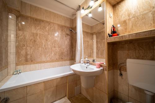 a bathroom with a sink and a tub and a toilet at Lilla Apartments in Odorheiu Secuiesc