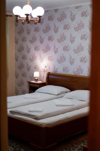 a bedroom with two beds with pink floral wallpaper at Lilla Apartments in Odorheiu Secuiesc