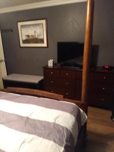 a bedroom with a bed and a dresser and a television at Curt's cozy room rentals in Wendover