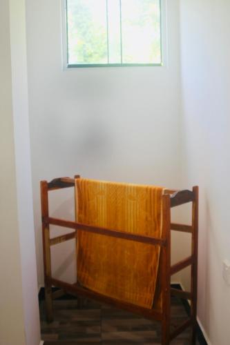 a wooden chair in a room with a window at Sunshine Guest in Madihe East