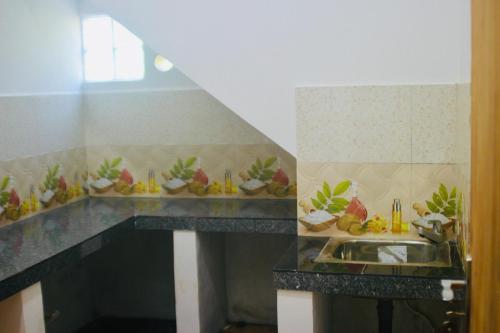 a kitchen with a sink and a counter with fruit on it at Sunshine Guest in Madihe East