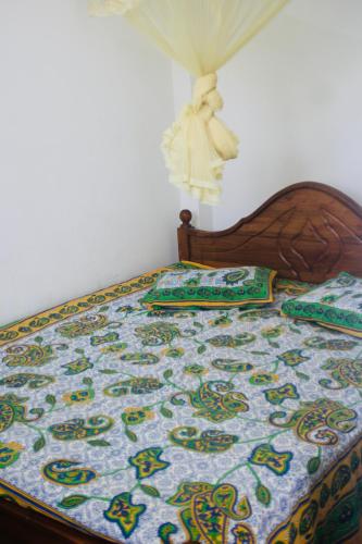 a bed with a quilt and pillows on it at Sunshine Guest in Madihe East