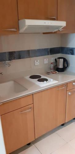 a kitchen with a stove and a counter top at Platinum Hotel Apartments in Abu Dhabi