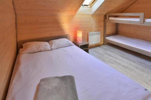 1 dormitorio con 1 cama en una cabaña de madera en Comfortable holiday homes, sauna, Sianozety, en Sianożęty