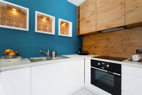 a kitchen with white cabinets and a black oven at Holiday Home in Ustronie Morskie near Beach in Ustronie Morskie