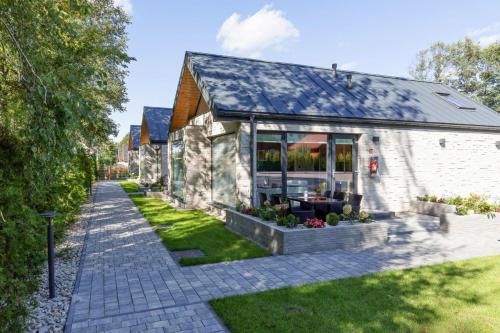a stone house with a garden in front of it at Holiday Home in Ustronie Morskie near Beach in Ustronie Morskie