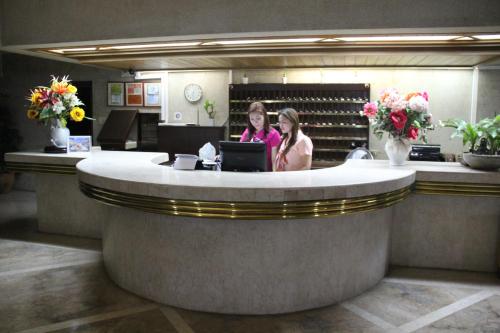 two women sitting at a counter in a hotel lobby at Maharajah Hotel in Angeles