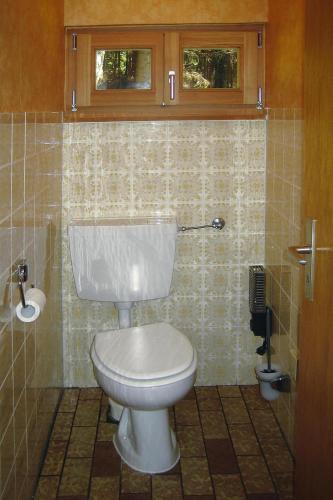 a bathroom with a white toilet in a tiled room at Blockhaus in Rinchnach mit Panoramablick in Rinchnach