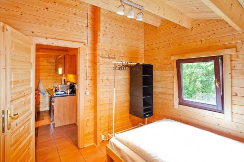 a bedroom in a log cabin with a bed and a window at Row bungalows, Sianozety in Sianozety