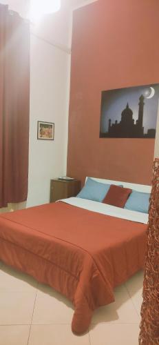 a bedroom with a large bed with a red blanket at B&B IL POETA in Palermo