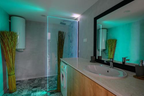 a bathroom with a sink and a glass shower at Гардън Апарт in Blagoevgrad