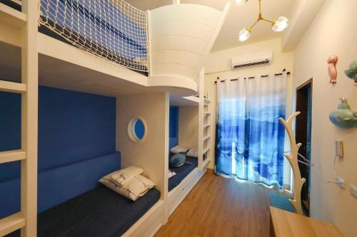 a room with two bunk beds and a window at 墾丁藍洞青旅 Blue Hole Backpacker Inn in Hengchun South Gate