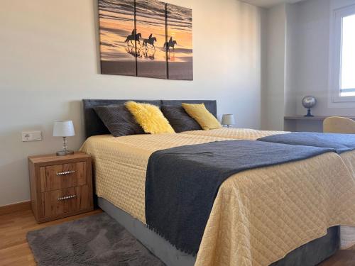 a bedroom with a bed and a painting on the wall at Sol y Mar in El Campello
