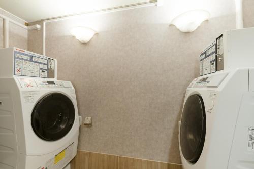 a washing machine and a dryer in a bathroom at The OneFive Garden Kurashiki in Kurashiki