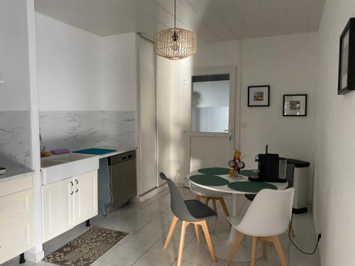 une cuisine avec une table et des chaises dans une pièce dans l'établissement Gîte du CIrque, à Châlons-en-Champagne