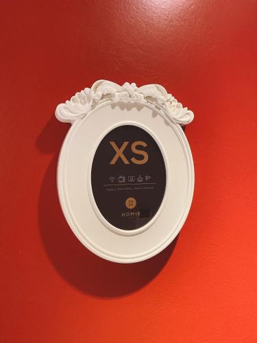 a clock on a wall with the word x on it at Homie B&B in Hualien City