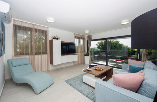 a living room with a blue couch and a tv at Villa Marija in Sveti Filip i Jakov