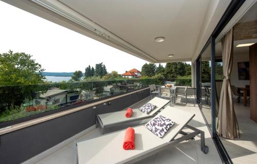 a balcony with couches and a view of the water at Villa Marija in Sveti Filip i Jakov