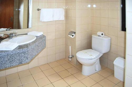 ein Badezimmer mit Toilette und Waschbecken in der Unterkunft Chalet in Lagoa with Natural Pools Nearby in Rosário-Lagoa