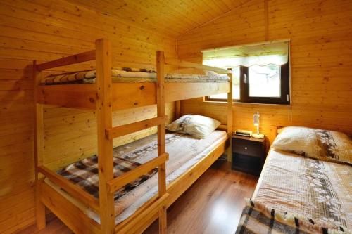 ルシノボにあるholiday home, Rusinowoのログキャビン内のベッドルーム1室(二段ベッド2組付)