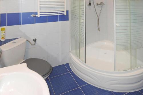 een badkamer met een douche, een toilet en een bad bij Holiday flat, Stepnica in Stepnica
