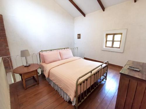 a bedroom with a bed with pink pillows and a table at La Toscana in Suan Phung
