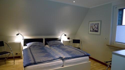 a bedroom with a bed with two lamps on it at Ferienwohnung Schuberski in Lipperreihe