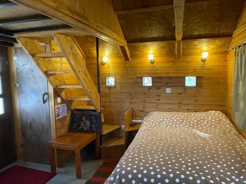 una camera con un letto in una cabina di legno di Villa Lochia - Η καλύβα του Τρύφωνα a Rámia
