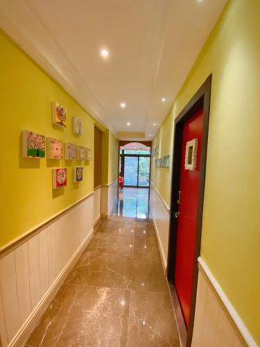 a hallway with a red door and yellow walls at Homie B&B in Hualien City