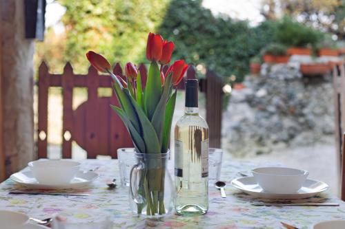 a table with a bottle of wine and a vase of flowers at Cascina Taronico in Bellagio