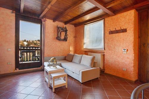 a living room with a couch and a large window at Cascina Taronico in Bellagio