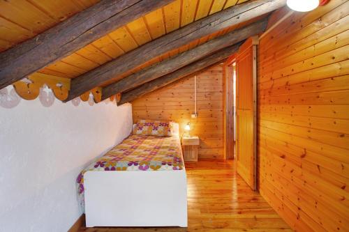 a bedroom with a bed in a wooden room at Cascina Taronico in Bellagio