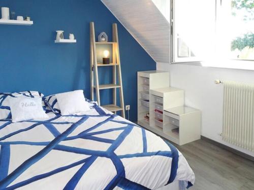 une chambre avec un lit et un mur bleu dans l'établissement Stone House in Brittany near Concarneau, à Fouesnant