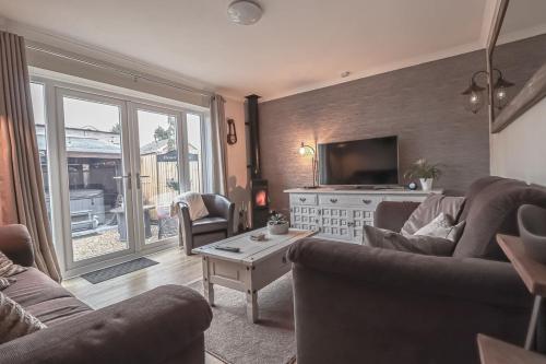 a living room with two couches and a television at Little Lodge Walcote Lutterworth in Lutterworth