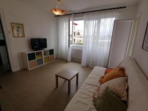 a living room with a couch and a table at Joli F2 en face de la gare de Paray-le-Monial in Paray-le-Monial