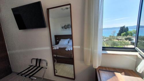 a mirror in a room with a bed and a window at Villa Ivan in Sveti Filip i Jakov
