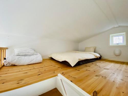 a bedroom with two beds and a wooden floor at Le Chalet Onsala in Onsala