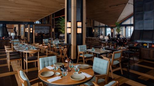 a dining room with wooden tables and chairs at Kaya Palazzo Ski & Mountain Resort in Kartalkaya