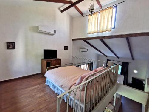 a bedroom with a bed and a television in it at La Toscana in Suan Phung