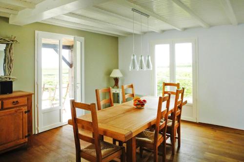 une salle à manger avec une table et des chaises en bois dans l'établissement Holiday Home in Chenac with Stunning Terrace Views, à Chenac Saint Seurin D'uzet